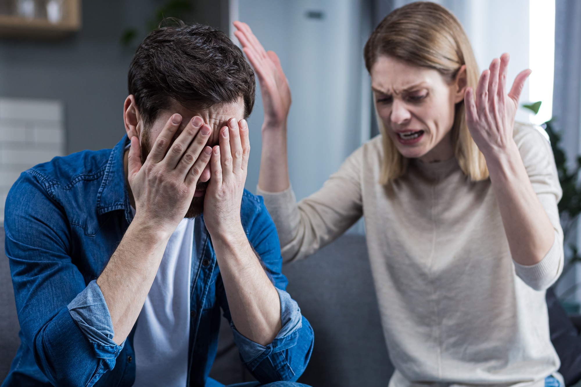 Family quarrel, woman quarrels and yells at the loser's husband, couple at home