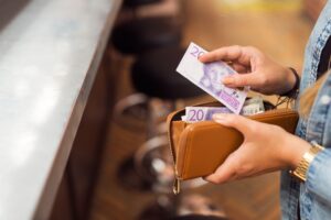 Woman paying with cash at bar